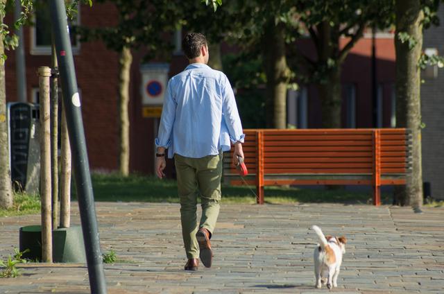 Man die een hond uitlaat op straat